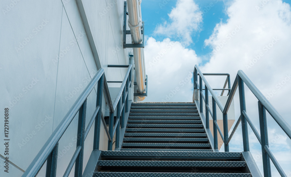 Fototapeta premium Industrial metal staircase with blue sky.