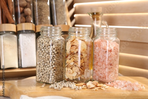 Wallpaper Mural Different aromatic spices in glass jars on table, closeup Torontodigital.ca