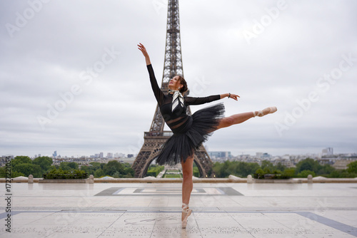 Photography Ballerina in black tutu performing ballet pose outdoors with the Eiffel Tower in the background in Paris, France