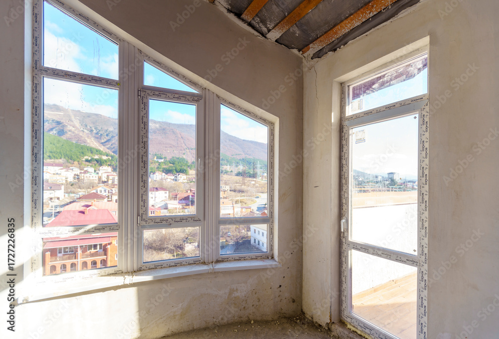 Fototapeta premium Room with window and view of water. Room in new building for fine finishing. Attic.