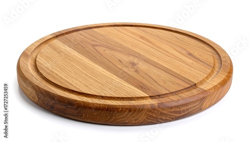 Wooden cutting board is round and grooved; on white background