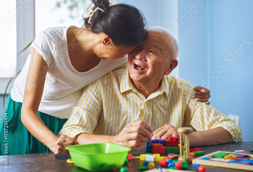 Senior man and woman enjoying skill block activity in assisted living