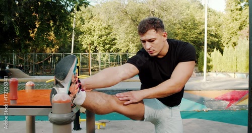 A Young Man Engaging in Stretching Exercises in an Outdoor Gym Setting Surrounded by Nature