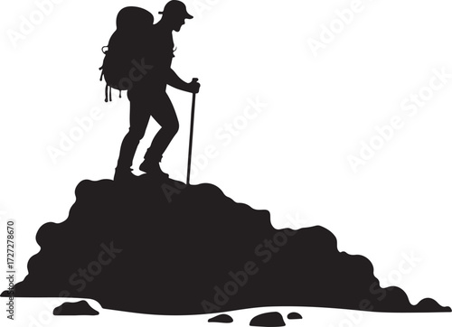 Silhouette of hiker with backpack and trekking pole on rocky terrain