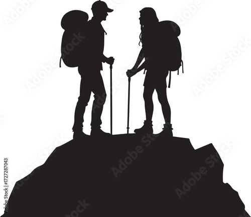 Two hikers with backpacks and poles on rocky peak silhouette