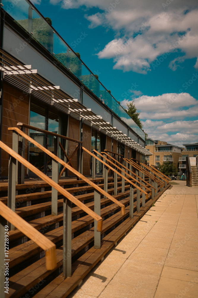 Obraz premium Modern Riverside Building with Wooden Steps and Glass Balustrade