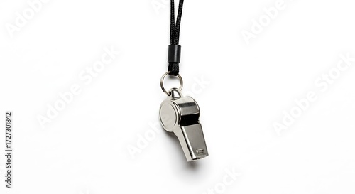 A shiny metal whistle with a black lanyard hanging against a plain white background in a studio shot