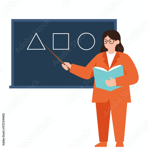 A female teacher in the classroom points at the blackboard while holding a book during a lesson