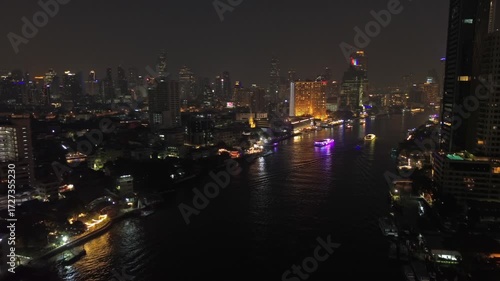 Aerial view of illuminated skyscrapers in Bangkok city and Chao Phraya River in night time, light show rays, 4k