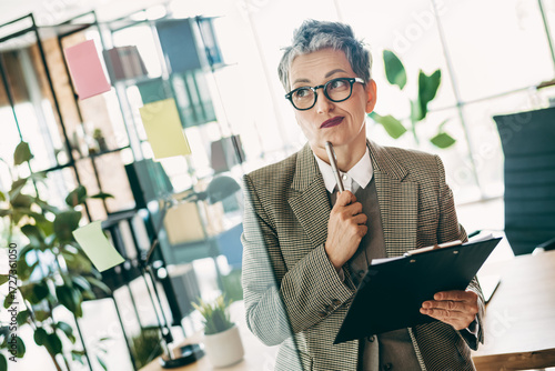 Schilderij op canvas Confident businesswoman planning strategy in a stylish office interior holding c