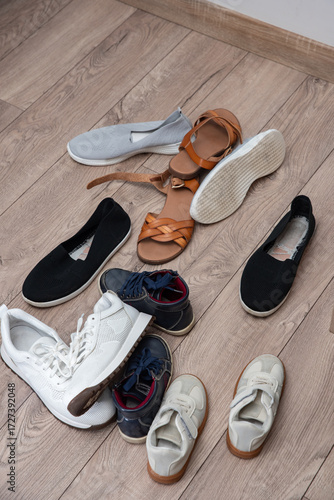 pile of women's and children's and teenage shoes lies on the floor, clean and dirty, worn. Decluttering and cleaning