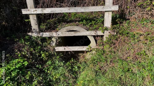 The entrance to a wildlife tunnel culvert under a busy country road. Safety for wild animals crossing the road.