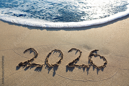 New Year 2026, lettering on the sunny beach sand.