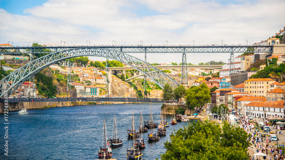 Obraz premium Porto, Portugal - July 10 2025: Stunning river scape of the Luis I steel bridge in Porto, Portugal