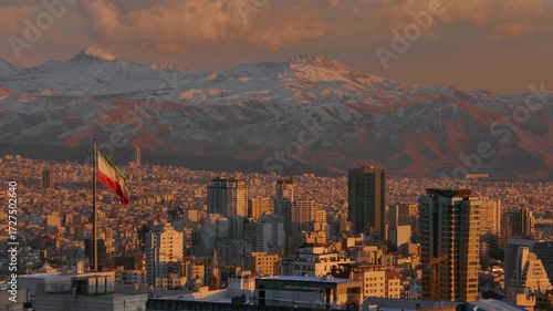 Golden sunset light over Tehran city with the Iranian flag waving in the foreground and the snow-covered Alborz mountains in the background, blending urban life with majestic nature.