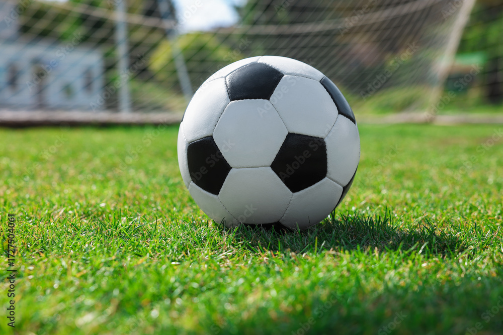 Fototapeta premium Soccer ball on green grass outdoors. Football game