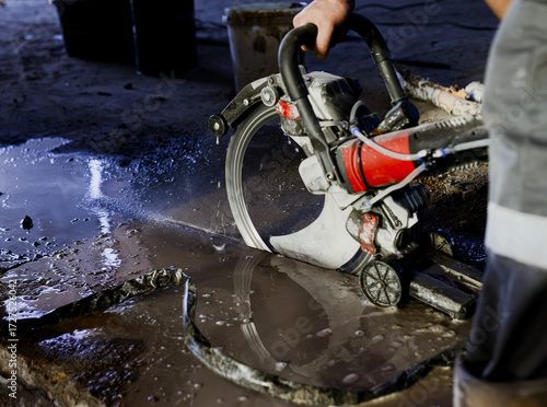 A worker saws a concrete floor with a ring concrete cutter. Special device for sawing concrete. High quality photo