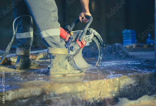 A worker saws a concrete floor with a ring concrete cutter. Special device for sawing concrete. High quality photo
