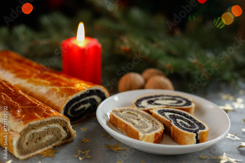 Sliced Christmas walnut and poppy seed rolls with candle