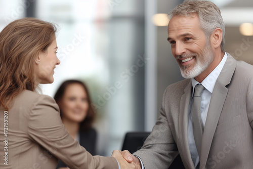 Wallpaper Mural Business woman and mature man shaking hands in a corporate office, indicating a successful negotiation, partnership, and forming a professional agreement in a meeting Torontodigital.ca