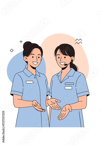 Two smiling nurses in blue uniforms are talking to each other.