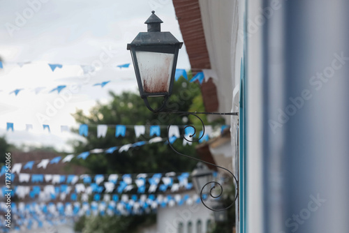 Rua de cidade histórica brasileira decorada com bandeirinhas azuis, destacando arquitetura colonial e atmosfera festiva.