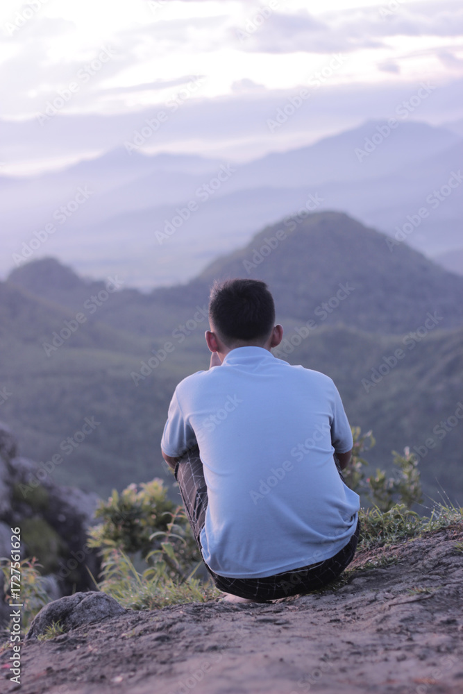 Naklejka premium man sitting on a rock mountain in Indonesia