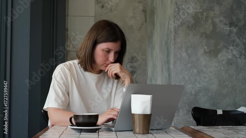 Focused Caucasian Woman Working on Laptop in Cafe