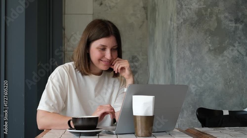 Cheerful Caucasian Woman Working on Laptop in Cafe