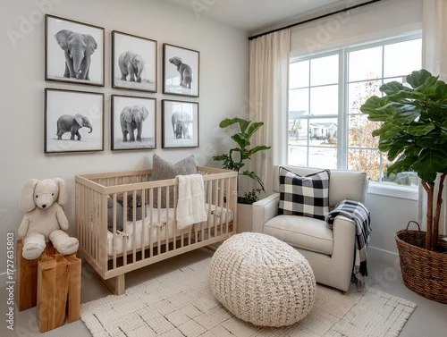 Obraz Nowoczesny, neutralny kolorystycznie pokój niemowlęcy w stylu safari. Drewniane łóżeczko, fotele w kratę i galeria czarno-białych zdjęć słoni.