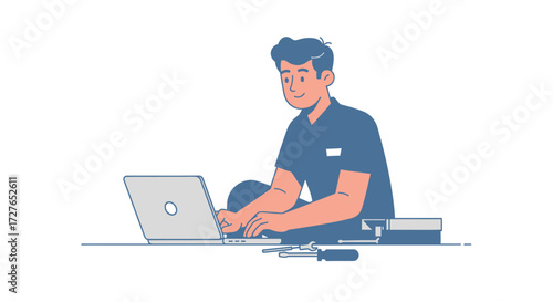 A focused young man in a blue t-shirt sitting on the floor working or studying on a laptop.