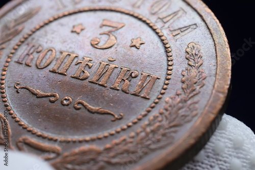 A close-up of an old copper coin featuring the denomination '3 копійки' with decorative elements