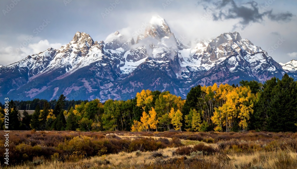Fototapeta premium Snowy mountain range with autumnal forests