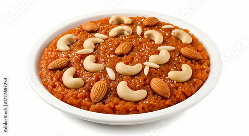 Gajar ka Halwa sweet dessert in white bowl with almonds and cashews in warm orange lighting on white background for Indian cuisine.