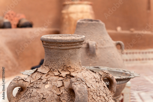 Outside area of a house decorated with several handmade clay vases standing upright. Daylight