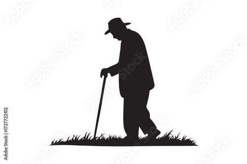 Silhouette of an elderly man walking with a cane in the grass