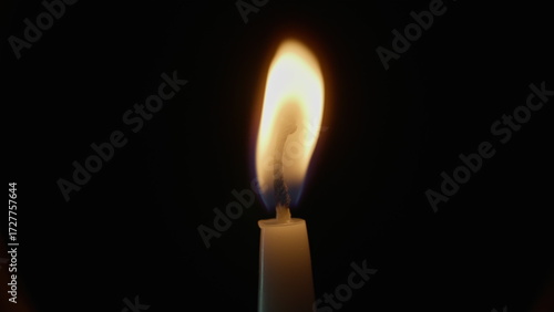 Quadro em tela Wind blowing candle flame on isolated black background