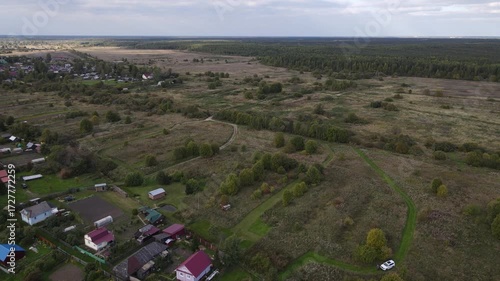 a small village or settlement on the edge of the forest in summer is captured from above from a drone