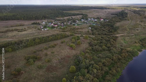 an old, out-of-the-way settlement in a remote area surrounded by forests, wooden houses stand in summer among greenery