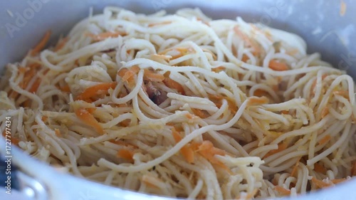 POV: A steaming pot of pasta. Someone mixing pasta in a pot. Close-up of a pan of pasta.