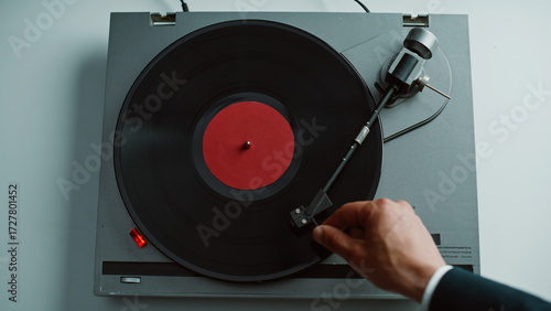 Photos Hand taking gramophone tonearm starting music playing in apartment closeup