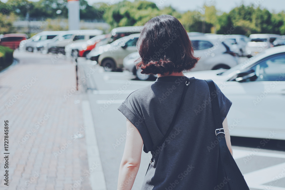 © beeboys - 駐車場内を歩く女性後ろ姿