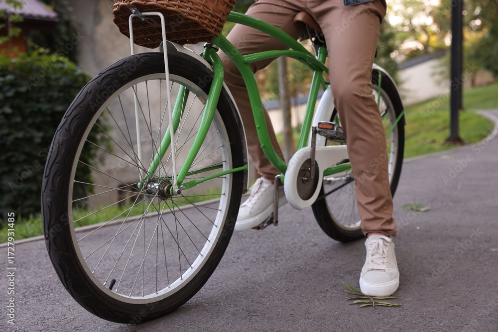 Fototapeta premium Man riding bicycle on city street, closeup