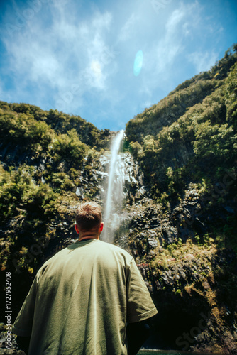 waterfall in the mountains with hiker in the foreground