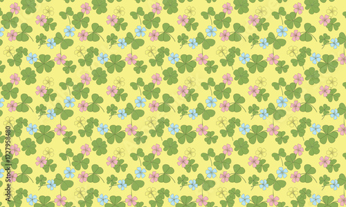 Seamless pattern of green clover leaves and small pink and blue flowers on yellow.
