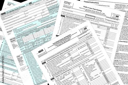 Tax year 2025 IRS 1040 and farming tax forms on a desktop.