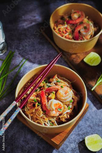 Pad Thai stir-fried with shrimp, eggs, peanuts and lime, served in paper.