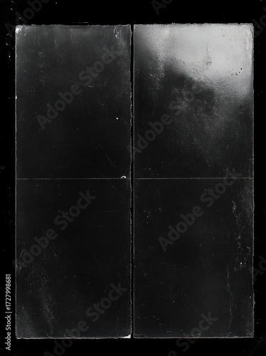 Close-up of four black rectangular tiles arranged in a 2x2 grid with a glossy texture and visible edges on a black background