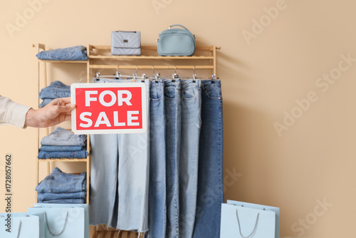 Female hand with FOR SALE s...