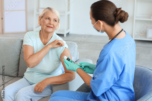 Senior woman receiving vacc...